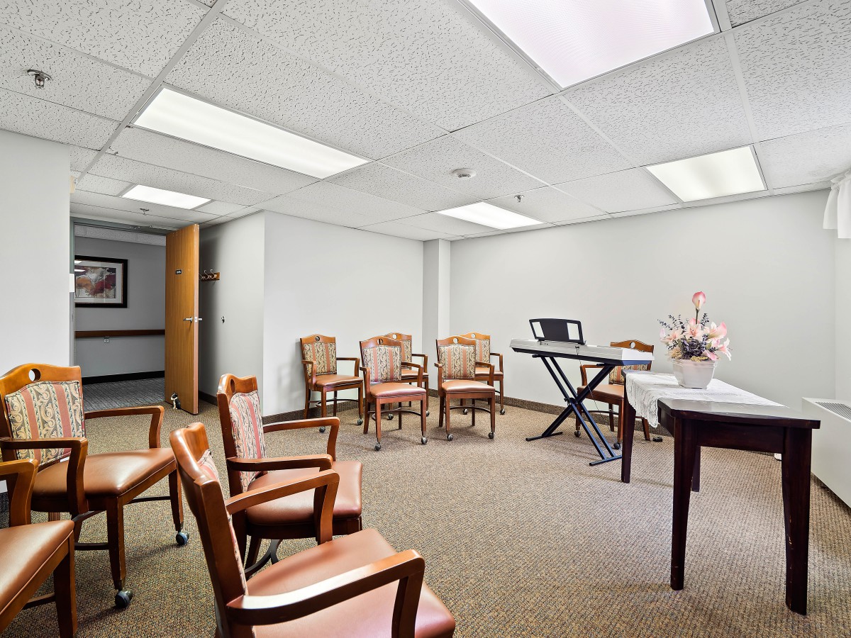 A simple and clean waiting room with arranged chairs and a table for meetings.