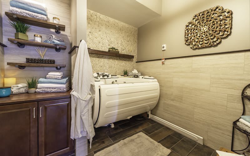 A cozy laundry room with shelves, a washing machine, and neatly stacked towels.