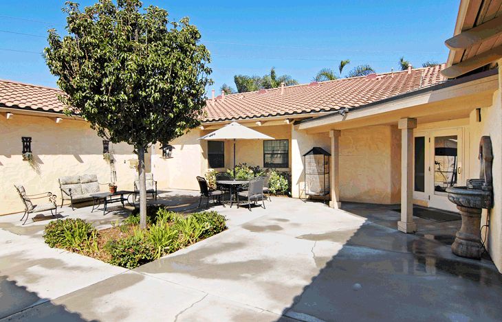 A sunny courtyard with outdoor seating and a landscaped garden.