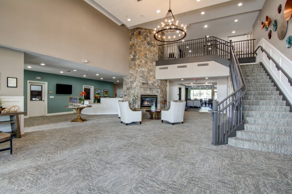 Spacious lobby with elegant chandelier, stone fireplace, and comfortable seating areas.