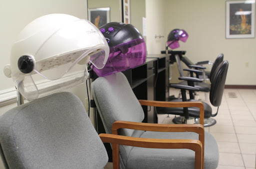 A salon interior featuring hair dryers and comfortable chairs.