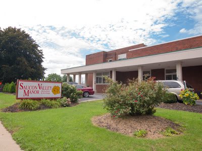The exterior view of a healthcare facility with surrounding greenery and a visible entrance sign.