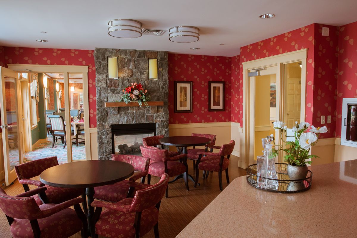 A cozy living room with a fireplace, red walls, and comfortable seating.