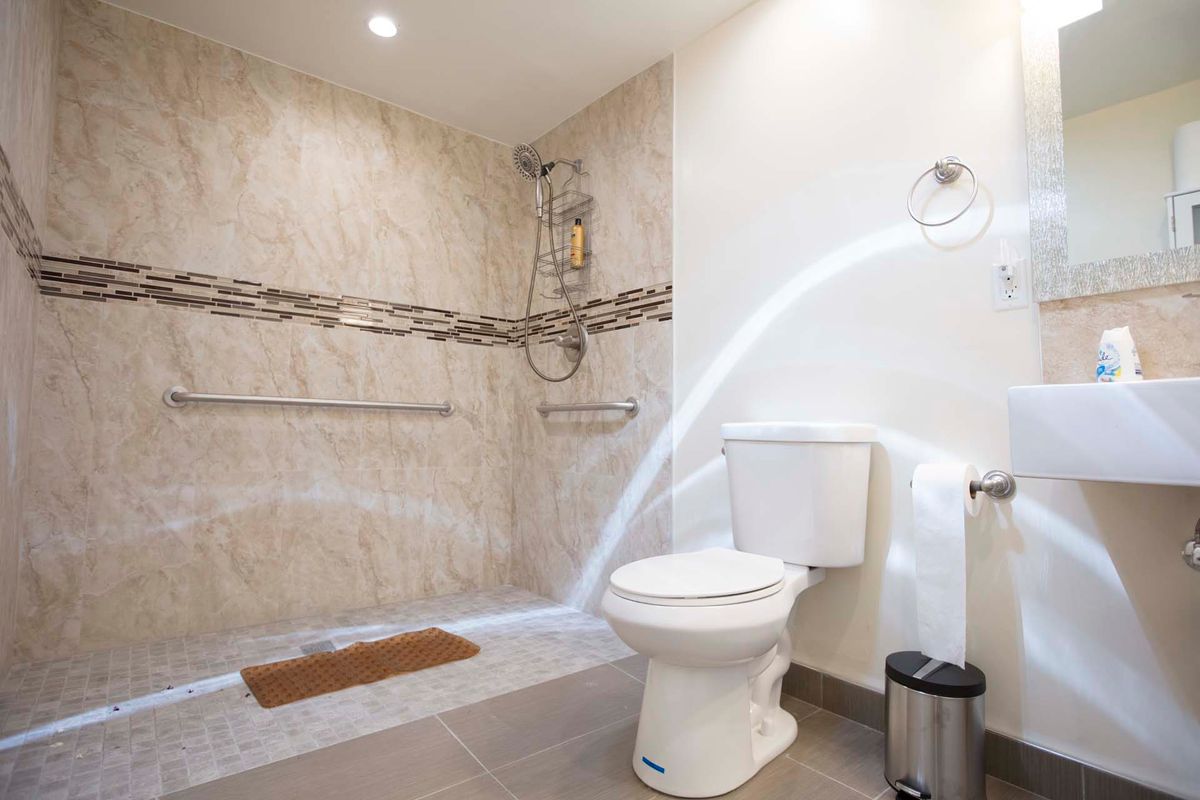 A modern bathroom with a shower area and toilet, featuring a water stream.