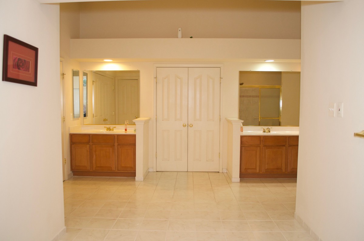 A spacious bathroom with double vanities and large mirrors.
