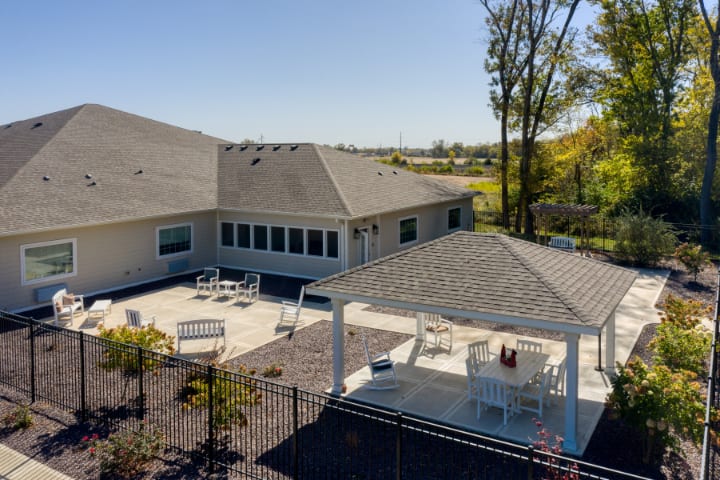 A spacious backyard features a patio area with outdoor seating and a gazebo, surrounded by well-maintained landscaping.