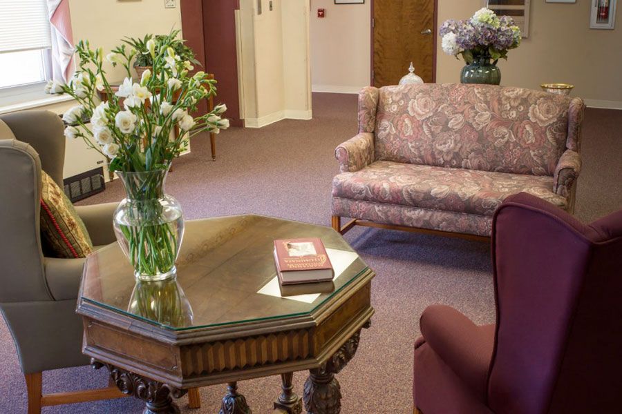 A cozy living room with a sofa, table, and flowers in a vase.