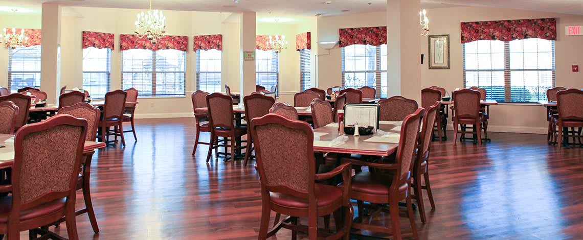 A cozy dining room with elegant furniture and wooden floors.