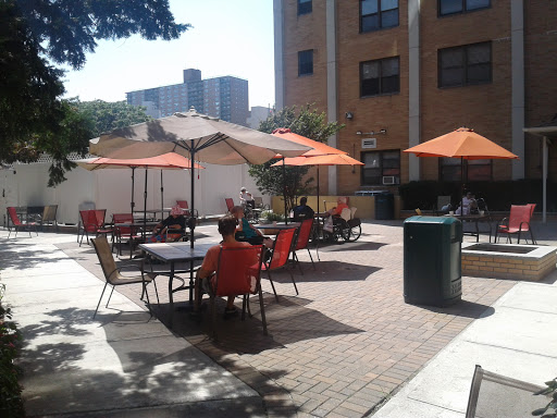 A sunny outdoor patio area with orange umbrellas and chairs, perfect for socializing.