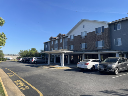A hotel building with a parking lot under a clear blue sky.