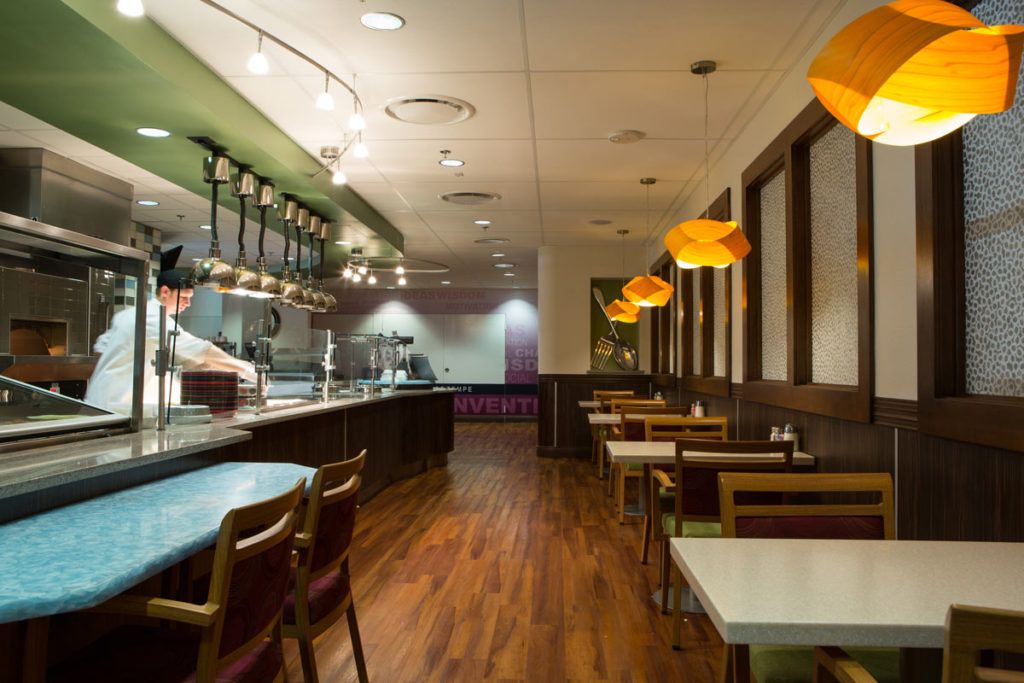A modern restaurant interior with a view of the dining area and open kitchen.