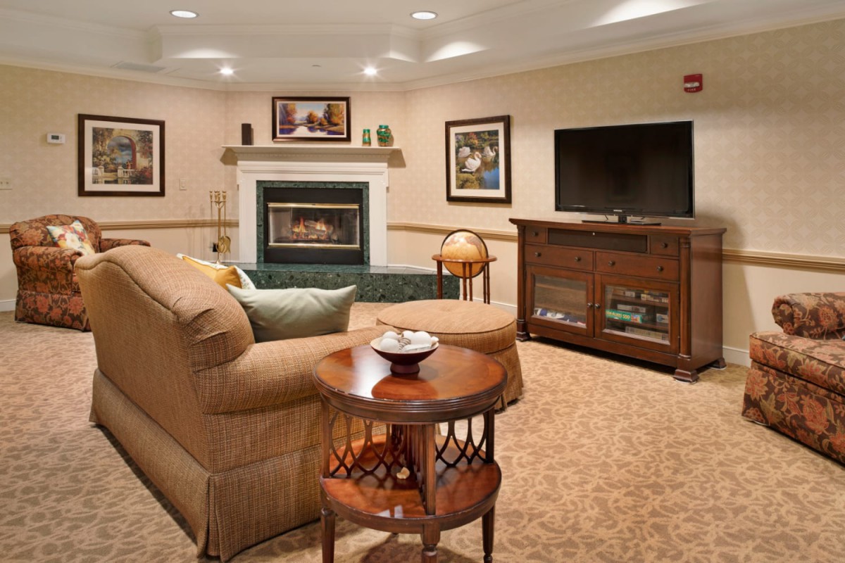 A cozy living room with a sofa, fireplace, and TV.