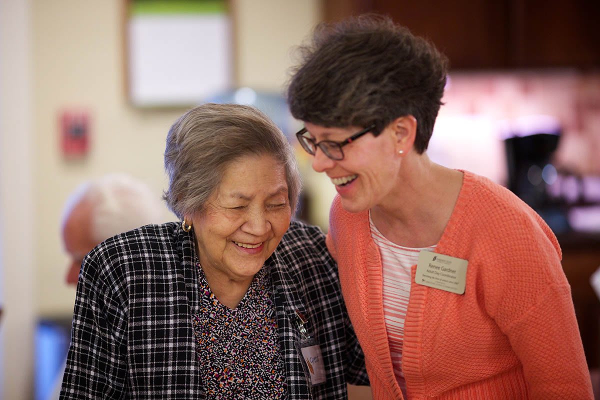 Two women smiling and enjoying a conversation together.