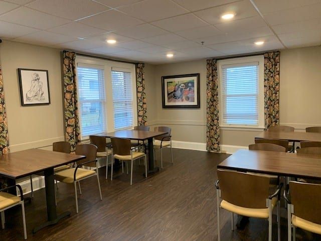 A cozy dining area with tables, chairs, and decorative artwork on the walls.