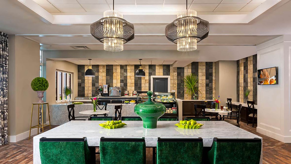A stylish dining area featuring modern pendant lights, a green color scheme, and elegant decor.
