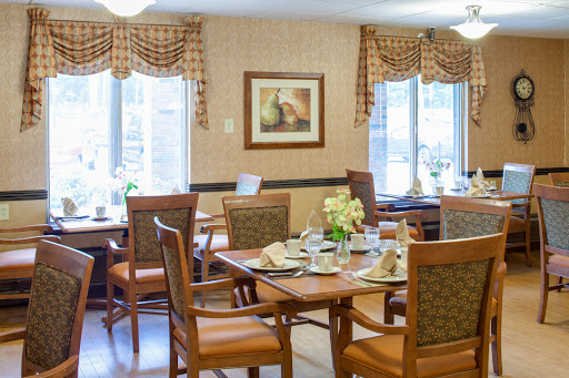 A cozy dining area featuring well-set tables and comfortable seating.