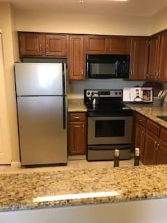 A modern kitchen with stainless steel appliances and wooden cabinets.
