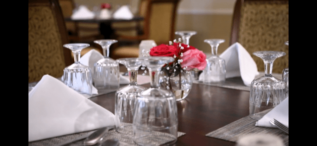 A beautifully set dining table with inverted glasses and floral centerpiece.