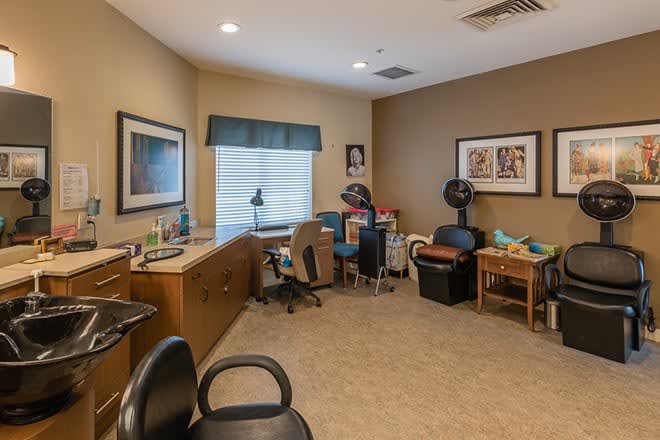 A cozy office space with a desk, chairs, and various decorations.
