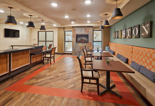 A modern dining area featuring stylish furniture and warm lighting.