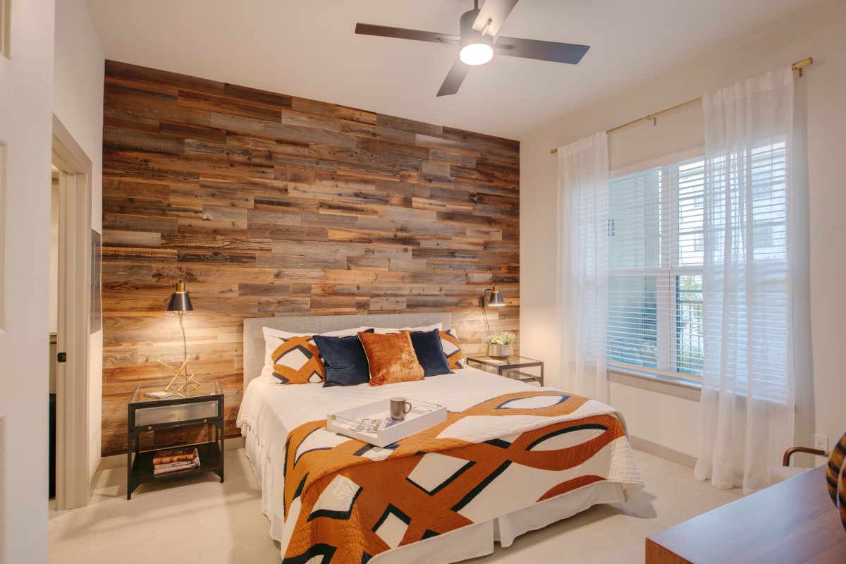 A cozy bedroom with a modern wood accent wall and stylish decor.