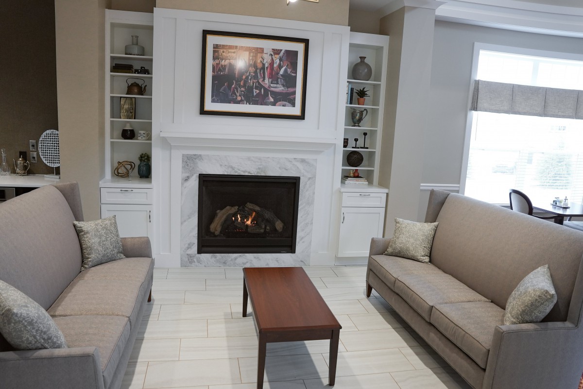 A cozy living room featuring a fireplace with built-in shelves, sofas, and a small coffee table.