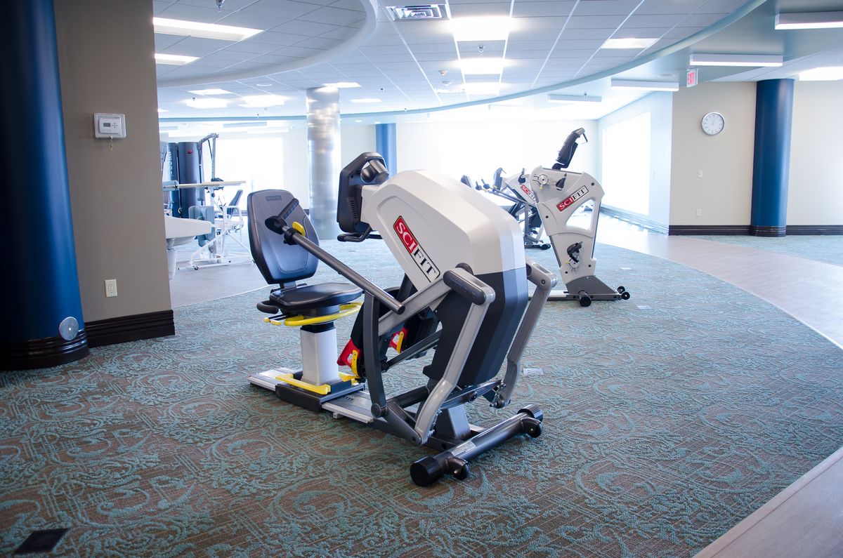 A modern gym with exercise equipment lined up in a spacious, well-lit room.