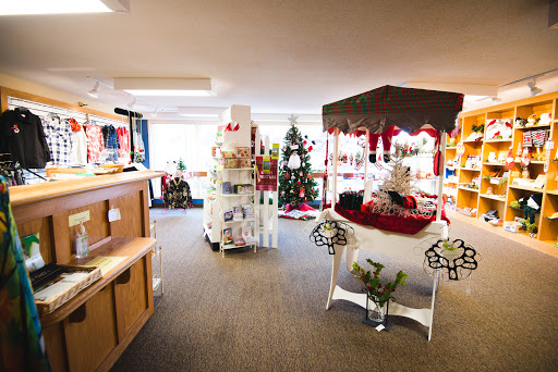 A cozy holiday-themed shop displaying Christmas decorations and gifts.