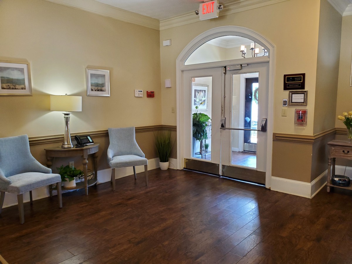 A cozy lobby area with wooden flooring, featuring seating and decorative elements.