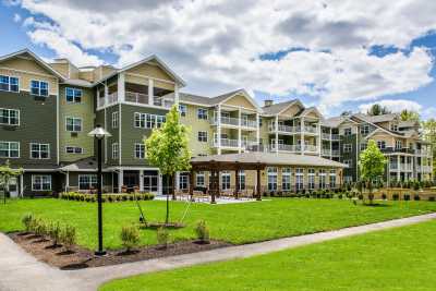 A modern apartment complex with a well-maintained green lawn and landscaping.
