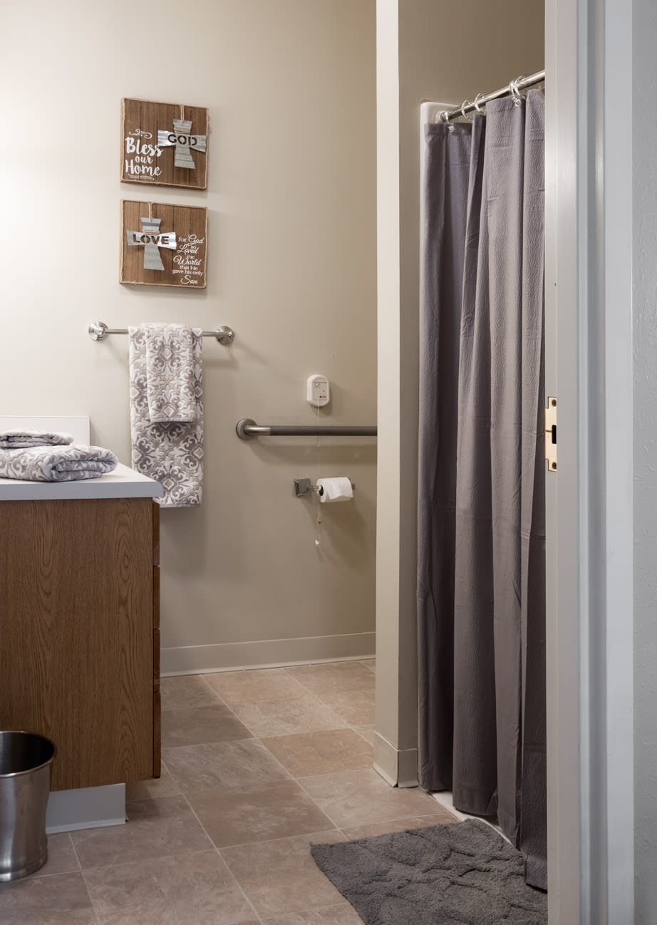 A well-organized bathroom with a sink, towels, and a shower curtain.