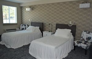 A neatly organized hotel room featuring two beds with white linens.