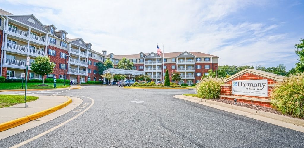 A multi-story residential building with American flags and landscaped surroundings.