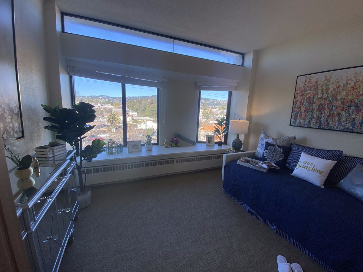 A modern living room with large windows offering a panoramic city view.