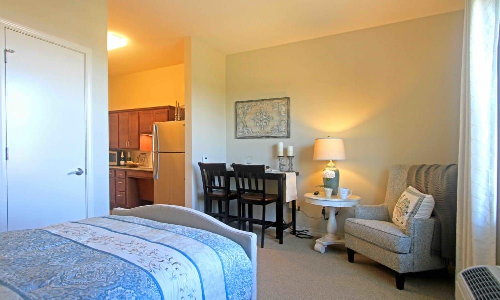 A cozy bedroom with a small dining area and warm lighting.