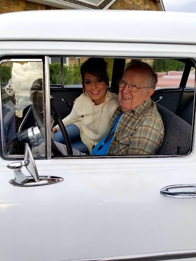 A joyful moment shared between a man and a woman inside a classic car.