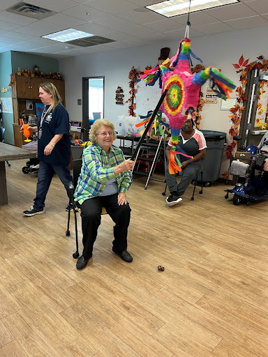 An engaging activity at a community center where elderly participants enjoy a colorful piata.
