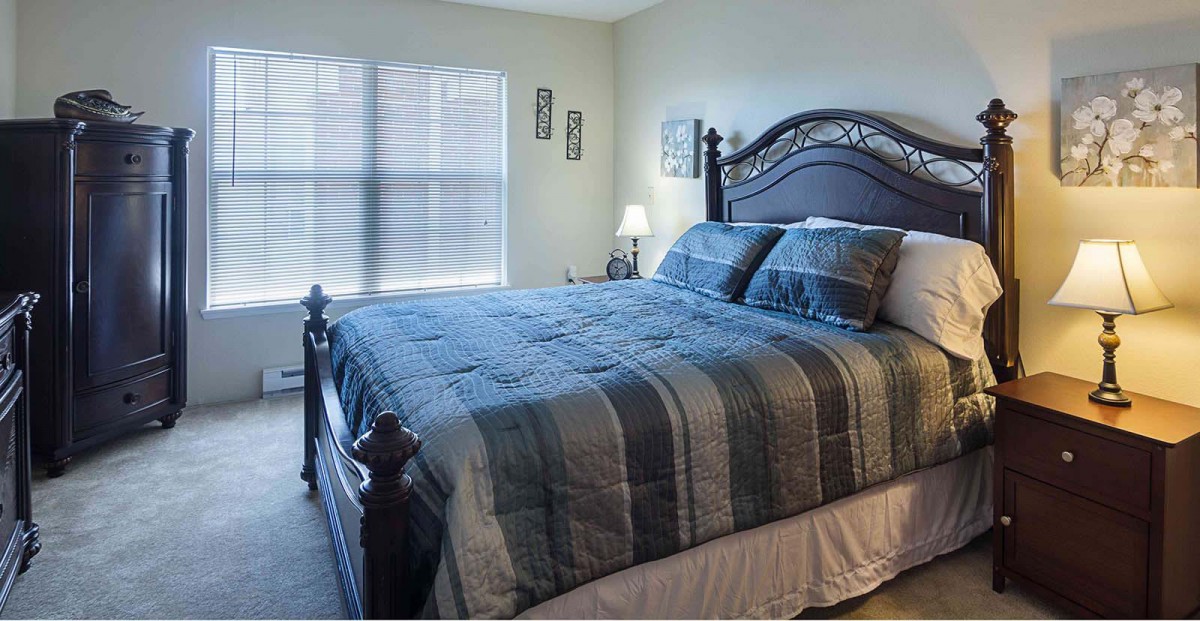 A cozy bedroom with a neatly made bed and soft lighting.