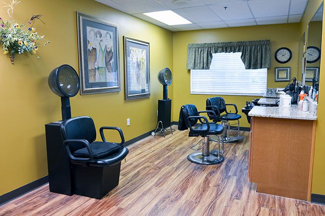 A cozy salon interior with seating and hair drying stations.
