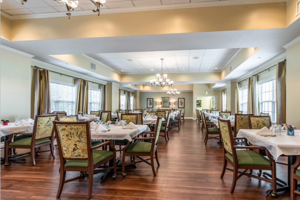 An elegant dining area with set tables and chandeliers.