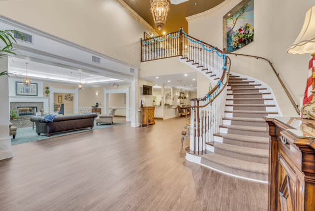 A spacious and elegant lobby featuring a grand staircase and chandelier.
