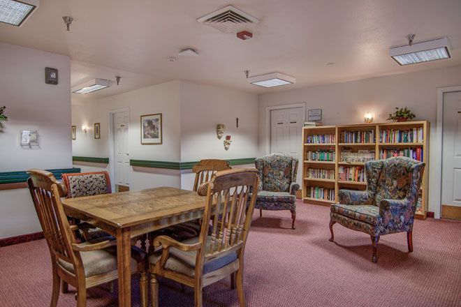 Cozy library reading room with bookshelves, tables, and chairs.
