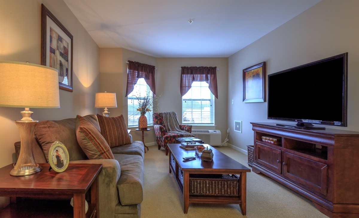 A cozy living room with a sofa, coffee table, and entertainment setup.