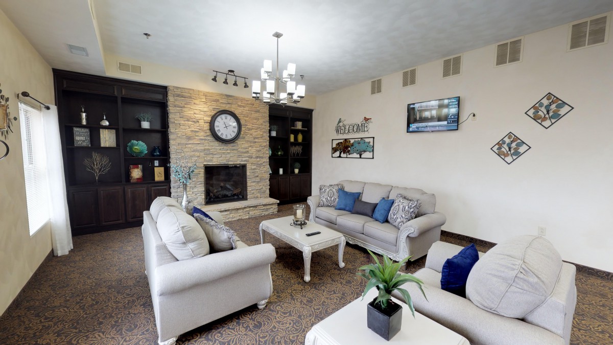 A modern living room with elegant furniture, a sofa set, coffee table, and a fireplace adorned with decorative elements.
