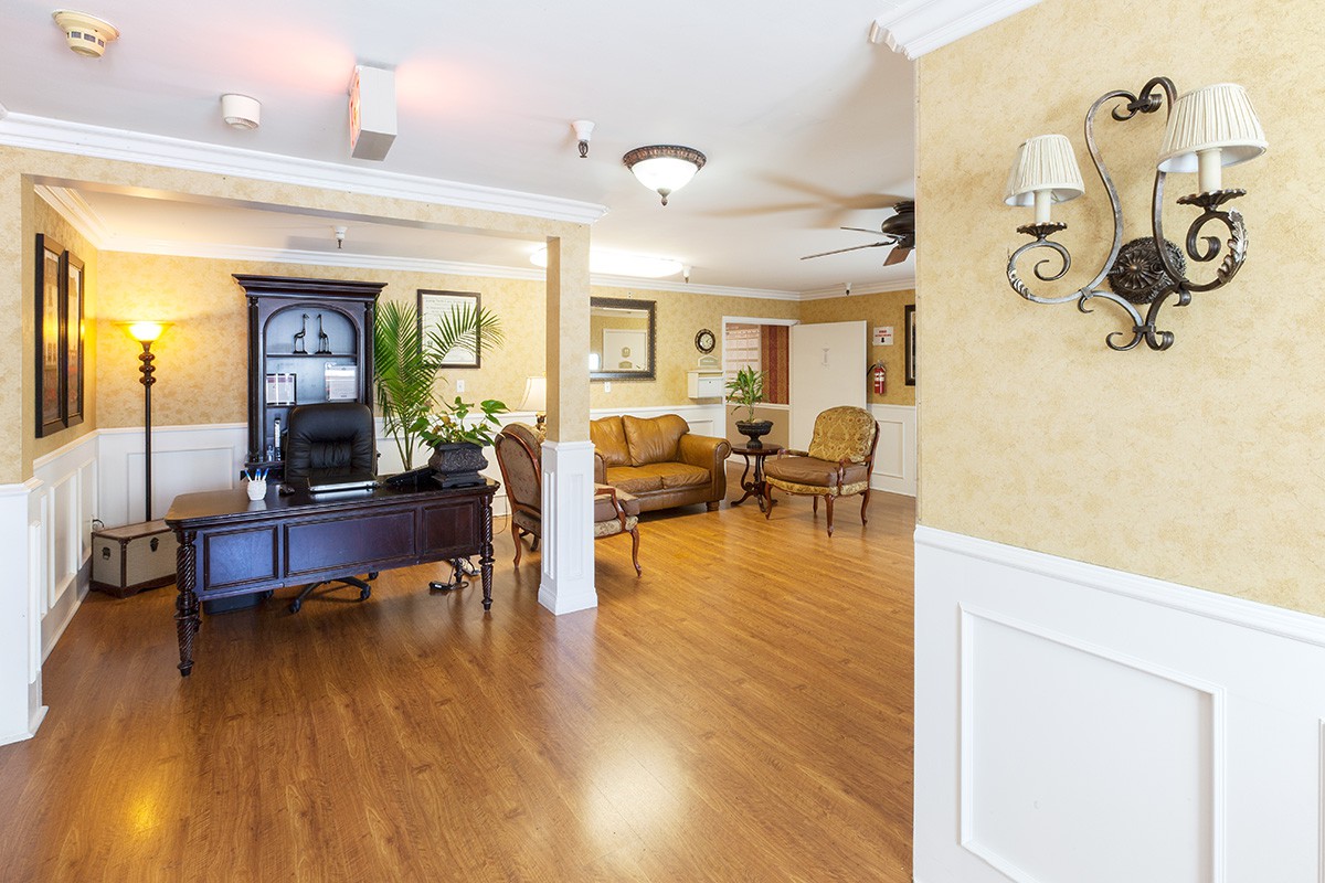 A well-furnished lobby area with wooden flooring, a sofa, and a decorative desk.