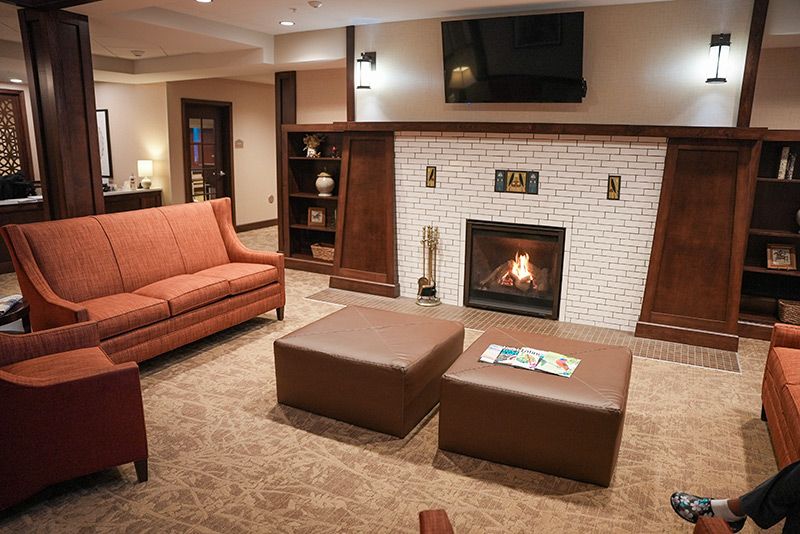 A cozy living room with a warm fireplace and comfortable seating.