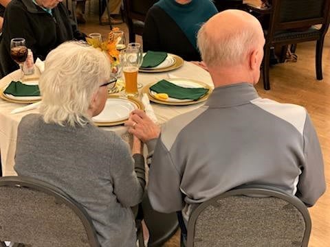 An elderly couple enjoys a meal together at a restaurant.