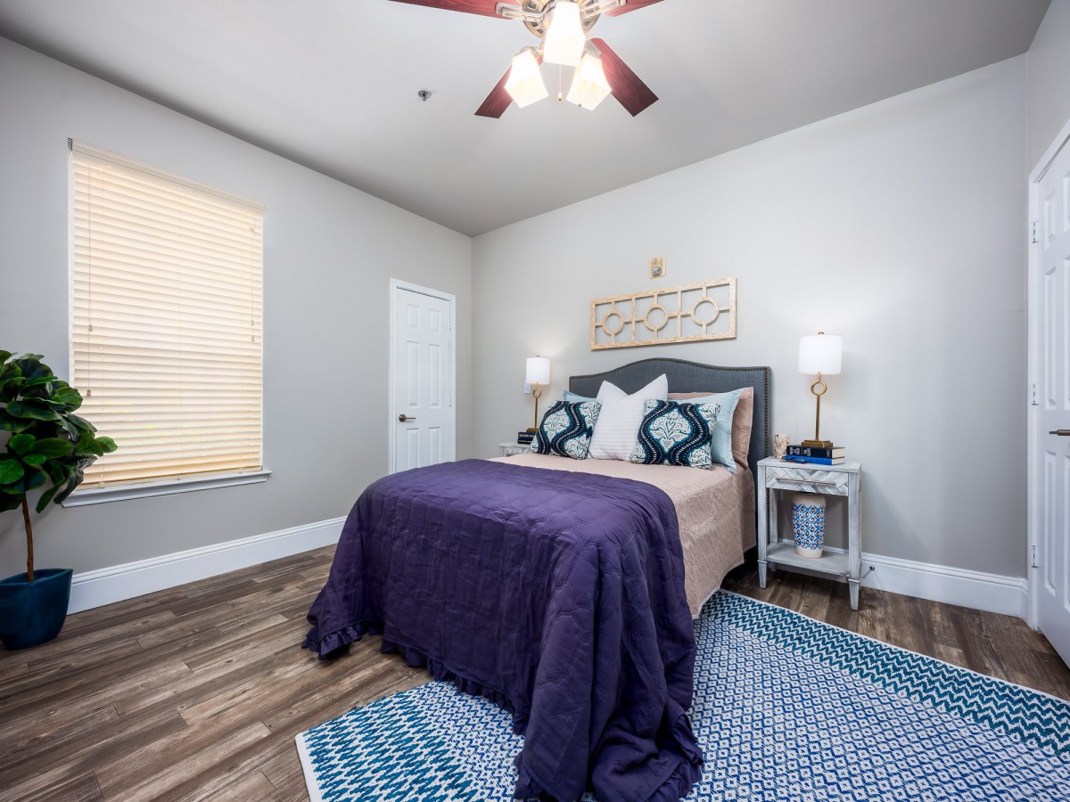 A cozy bedroom with modern decor and a ceiling fan.