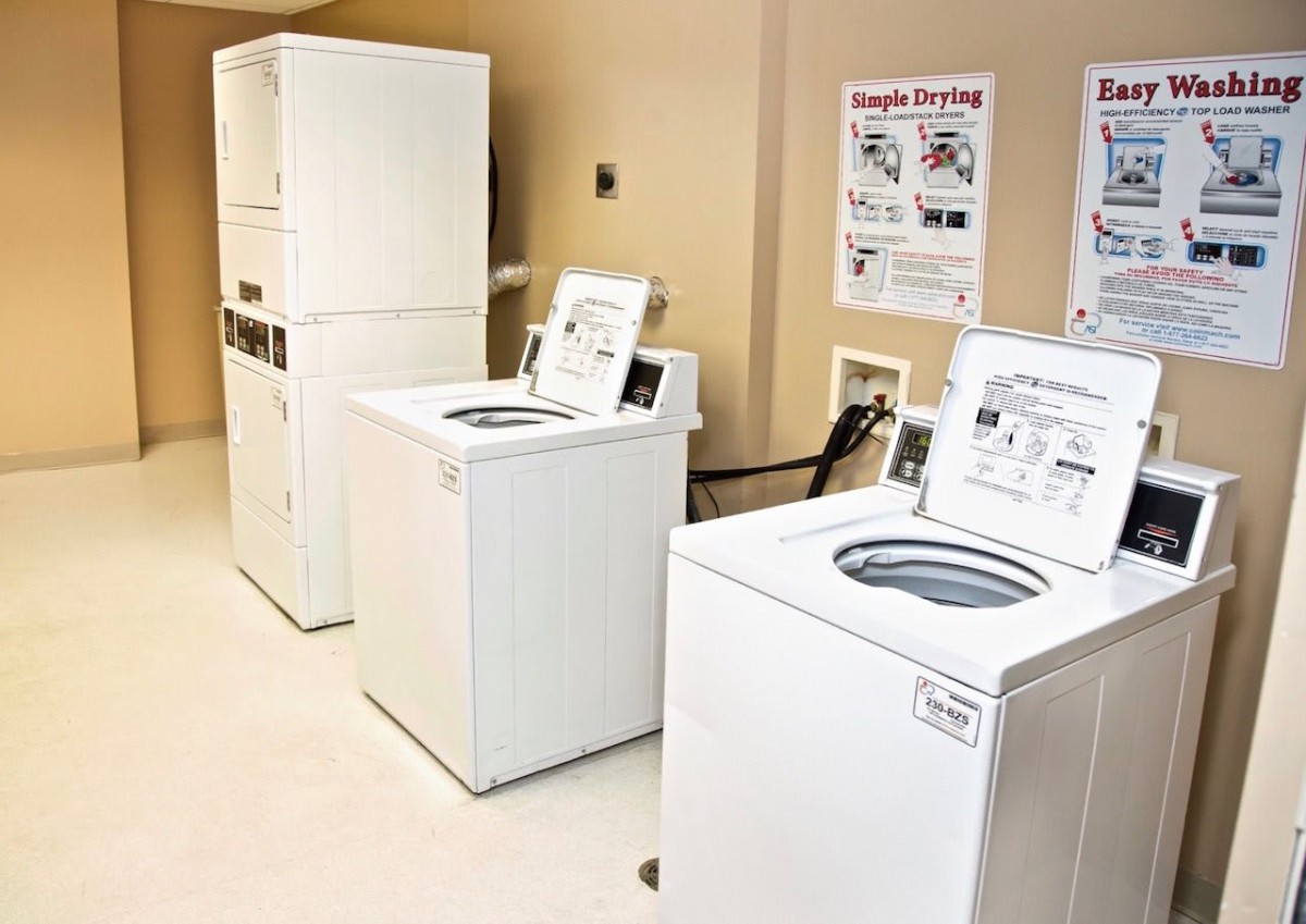 A clean and organized laundry room with washers and dryers.
