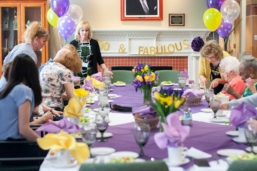 A vibrant gathering celebrating a special occasion with purple and yellow decorations.
